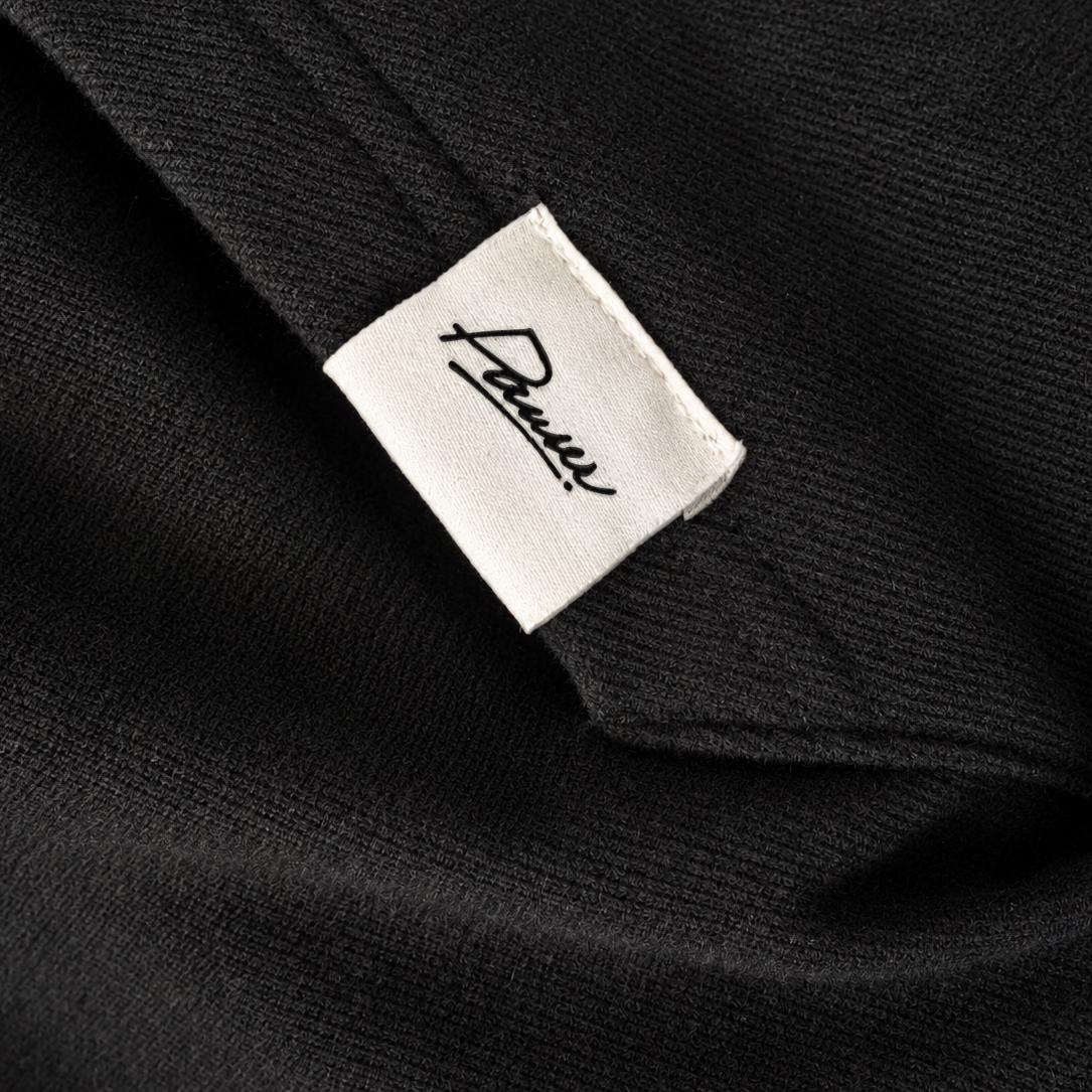 Detail tkaného Pauser labelu na černé hoodie